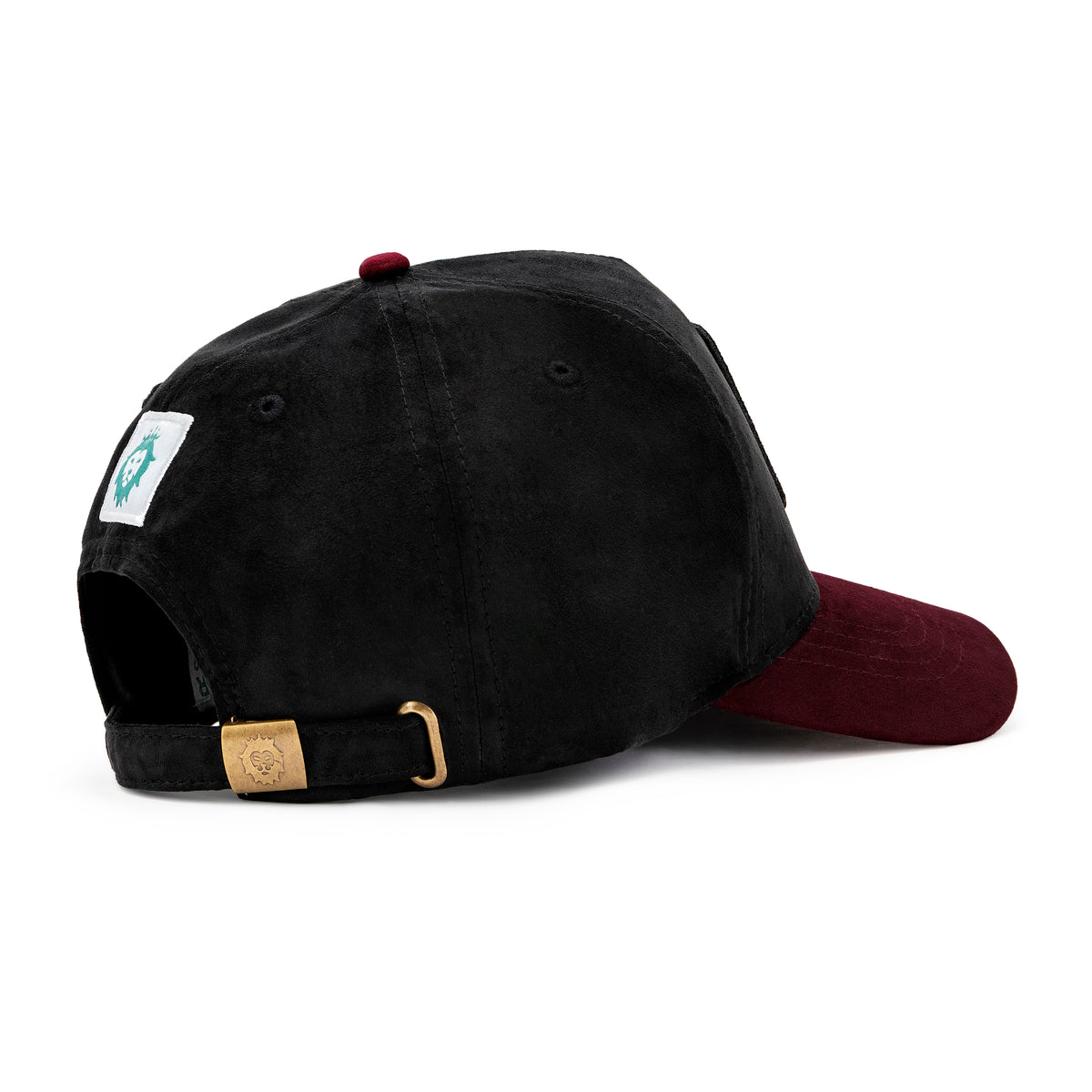 Side view of black and maroon suede cap with maroon NOGOR SHILPO embroidery and rabbit patch
