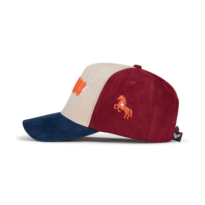 Side view of tri-color suede cap with orange embroidered rearing horse emblem on burgundy panel