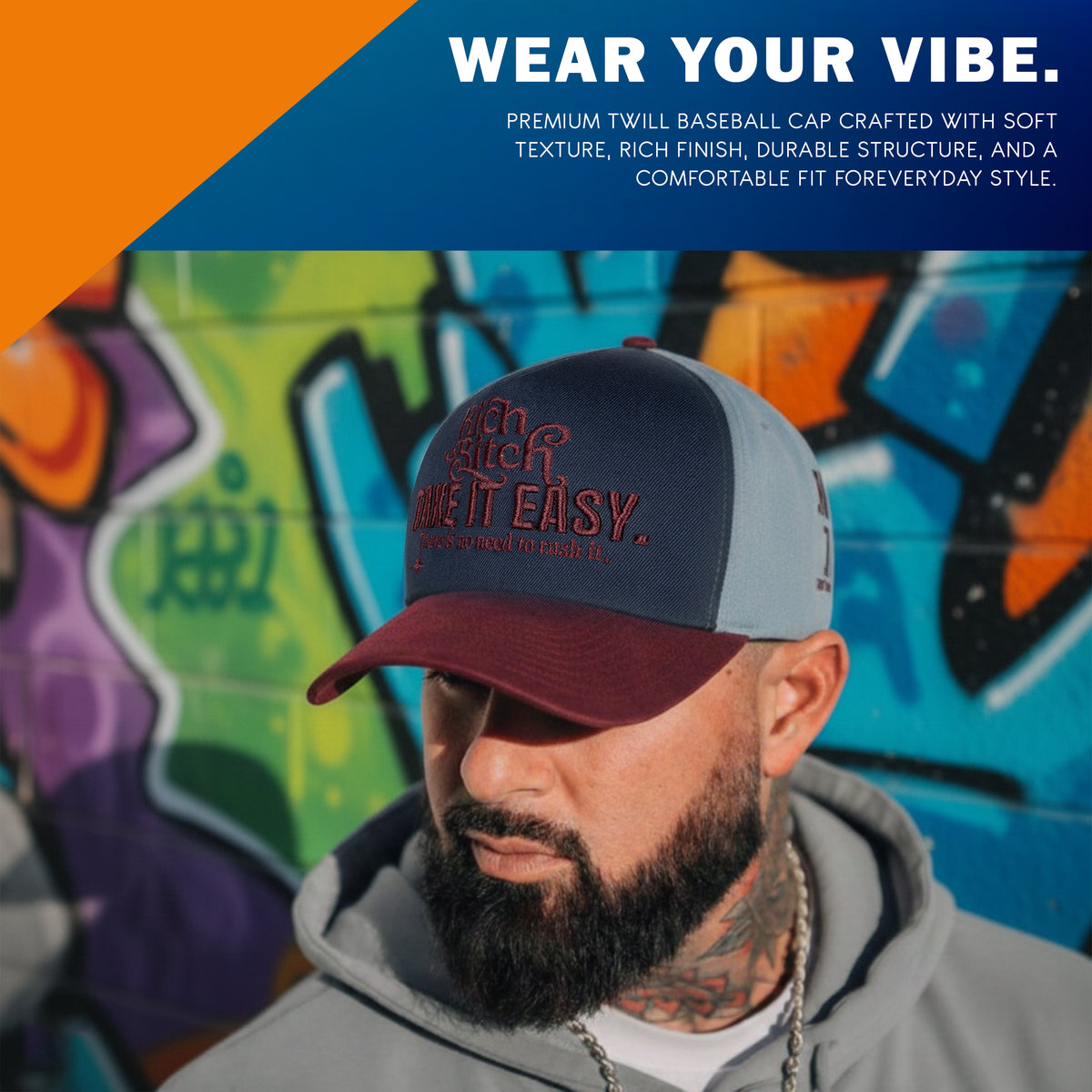 Side view of dusty blue cap panel with Own It and Rich Energy Only burgundy embroidery