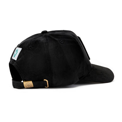 Side view of black suede cap with gold lion logo buckle and white woven lion label