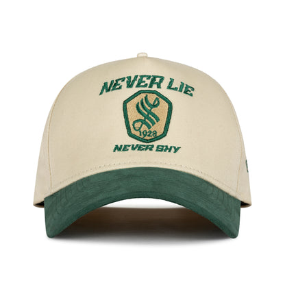 Side view of cream and green cap with Street Vibe green embroidery and woven emblem strap tab