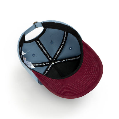 Two baseball caps, one gray and one burgundy, on a white background.